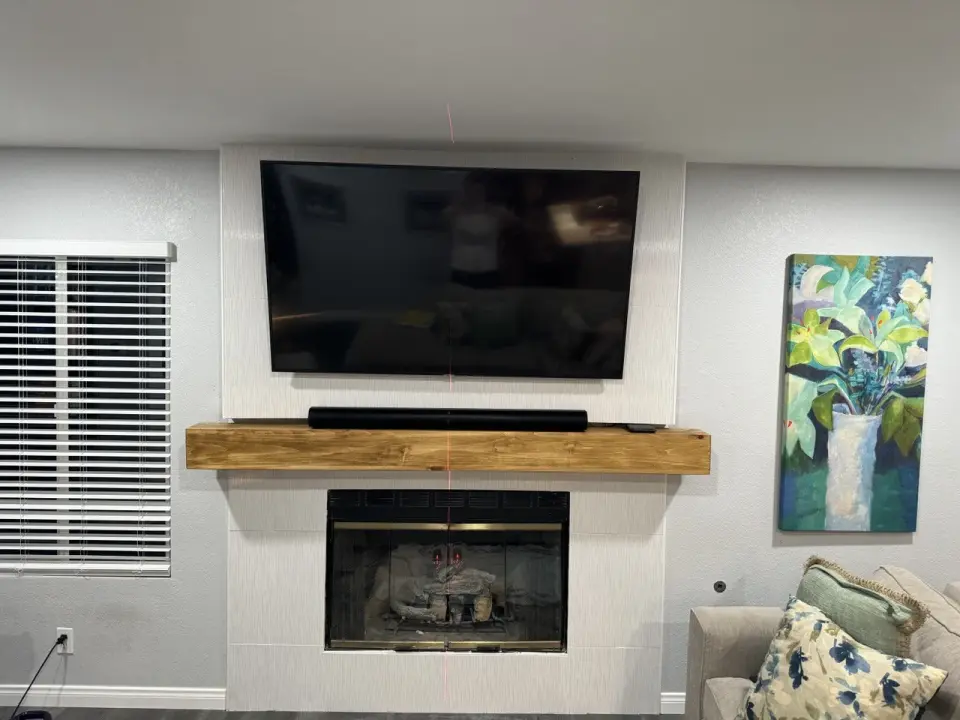 TV mounted above fireplace with soundbar